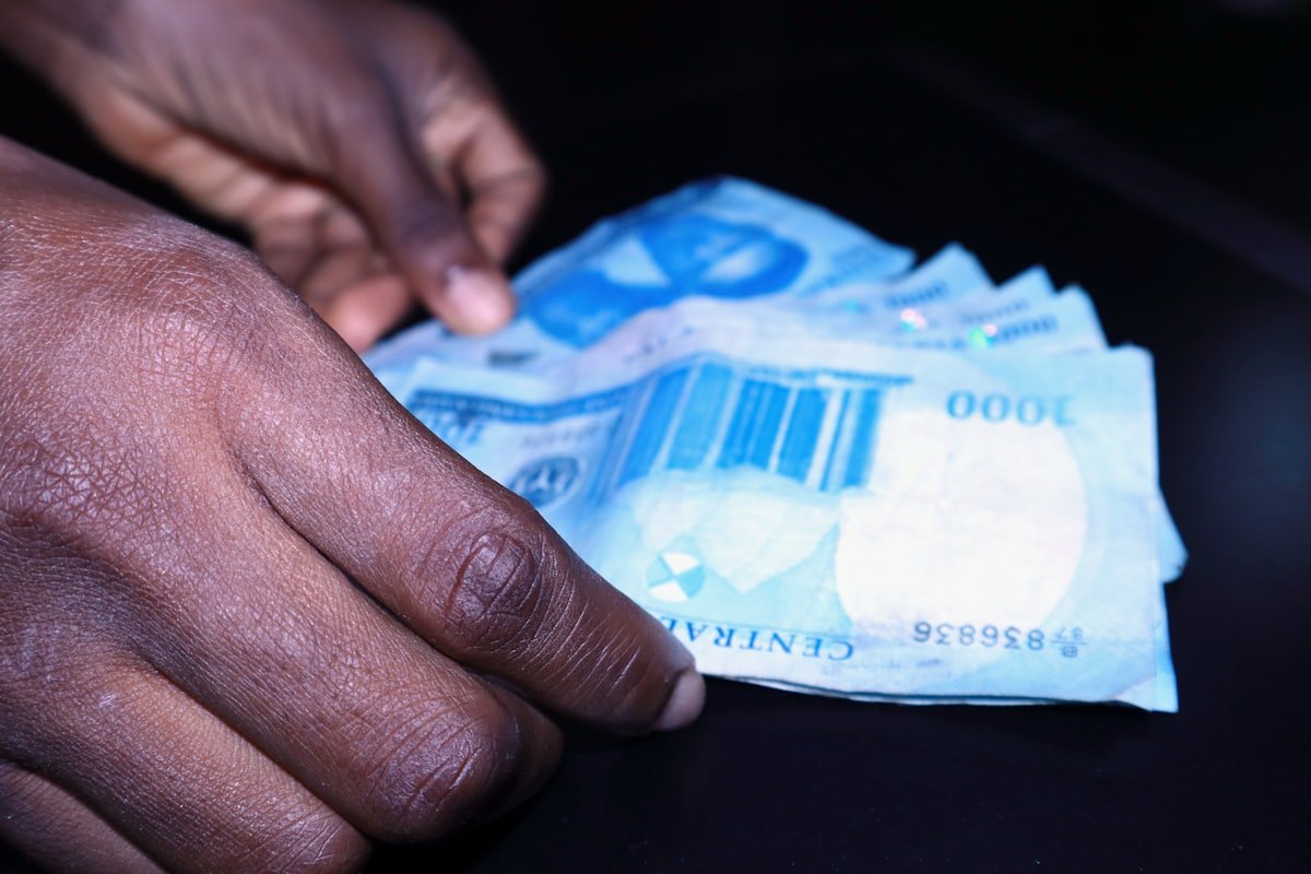 A hand reaching for naira notes, representing the cost of starting a gas business in Nigeria