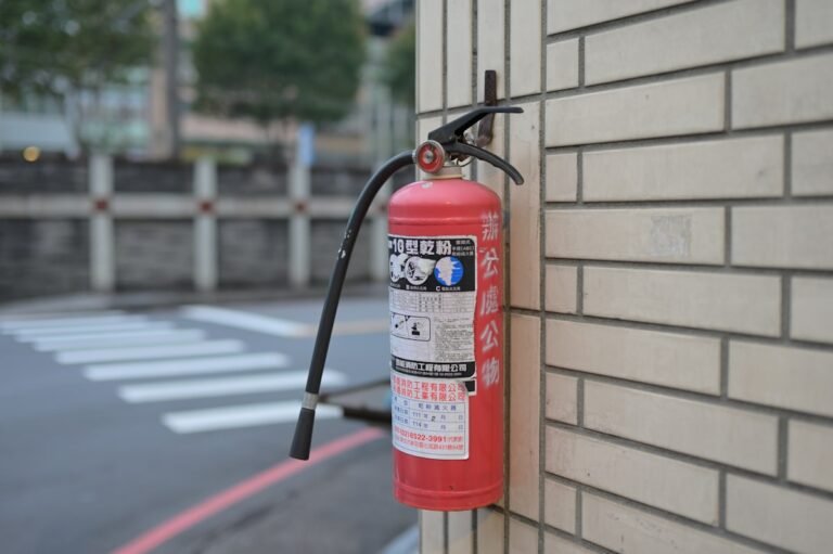 A red fire extinguisher mounted on a wall, essential kitchen fire safety equipment