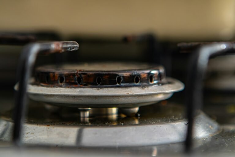 Used gas cooker burner area showing signs of wear and buildup