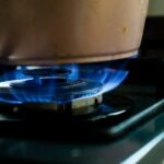 Gas stove burner with a cooking flame in a home kitchen