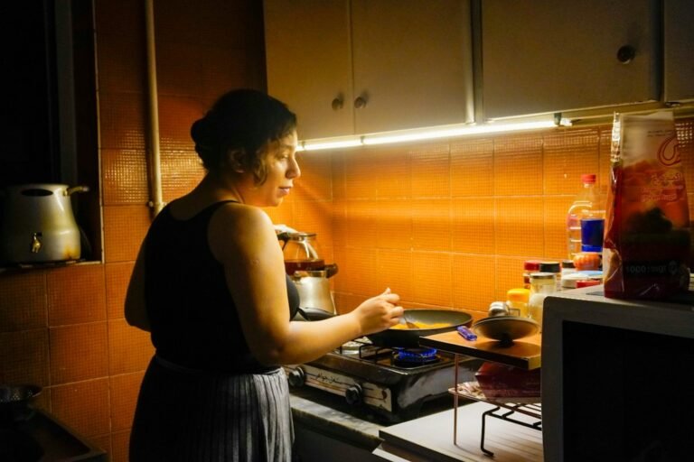 Woman cooking on a gas stove in a home kitchen